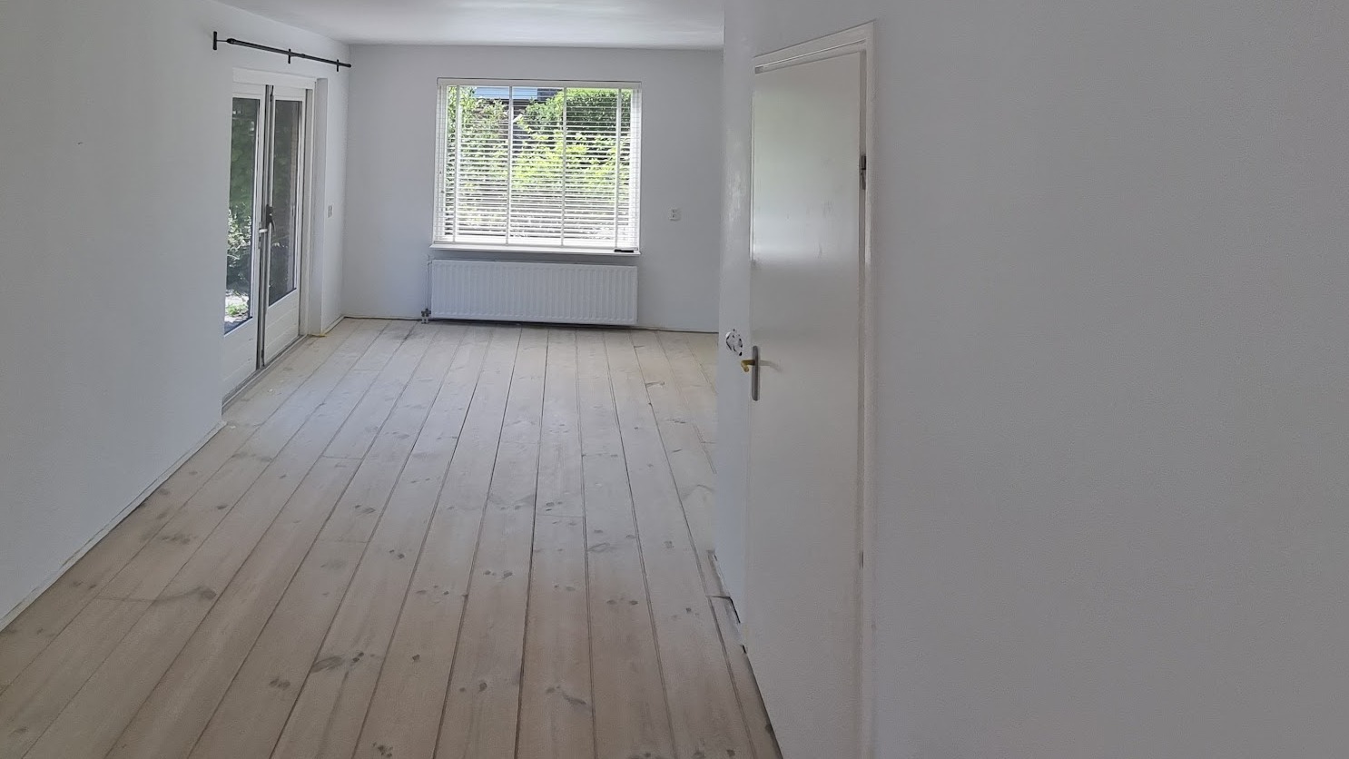 Vers gestucte witte woonkamer met houten vloer